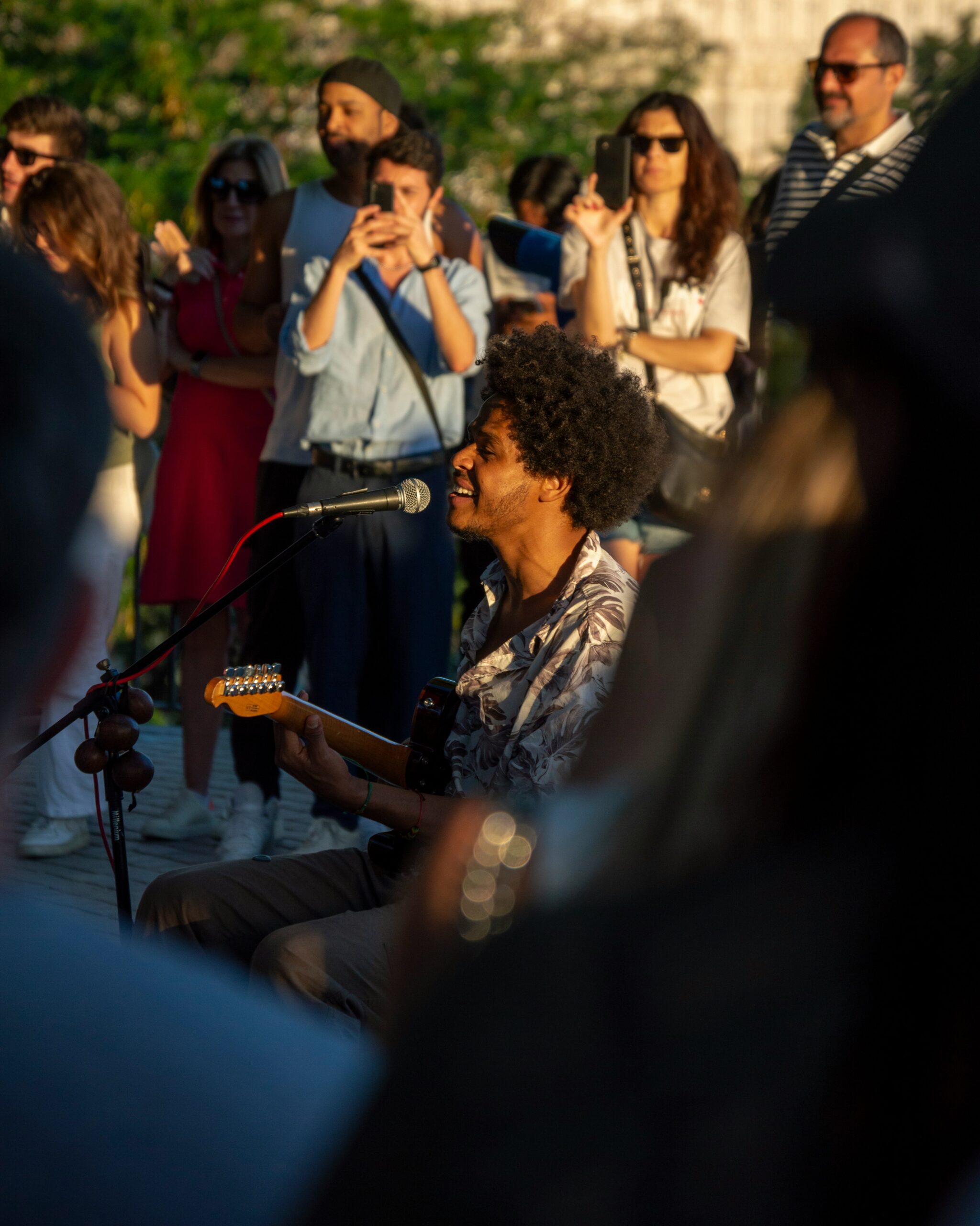 A man playing a guitar in front of a group of people